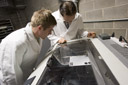 Designers using a laser cutter for a client's product invention prototype