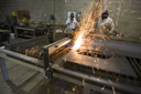 Designers using a plasma cutter for a client's invention prototype